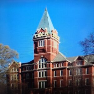 Historic brick building with a clock tower under a clear blue sky.